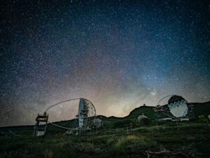Two Cherenkov gamma-ray telescopes silhouetted against a star-strewn sky at the Roque de los Muchachos observatory, La Palma.