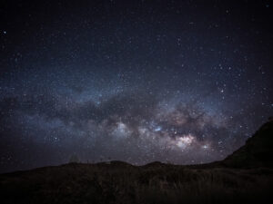 The Milky Way stretching above silhouetted observatory domes on a high ridge, Roque de los Muchachos, La Palma.