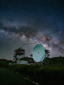 A MAGIC Cherenkov telescope's segmented mirror lit against the Milky Way's central bulge, Roque de los Muchachos observatory, La Palma.
