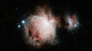 Deep-sky telescope image of the Great Orion Nebula (M42), its colourful gas clouds and the Running Man Nebula (NGC 1977) glowing nearby.